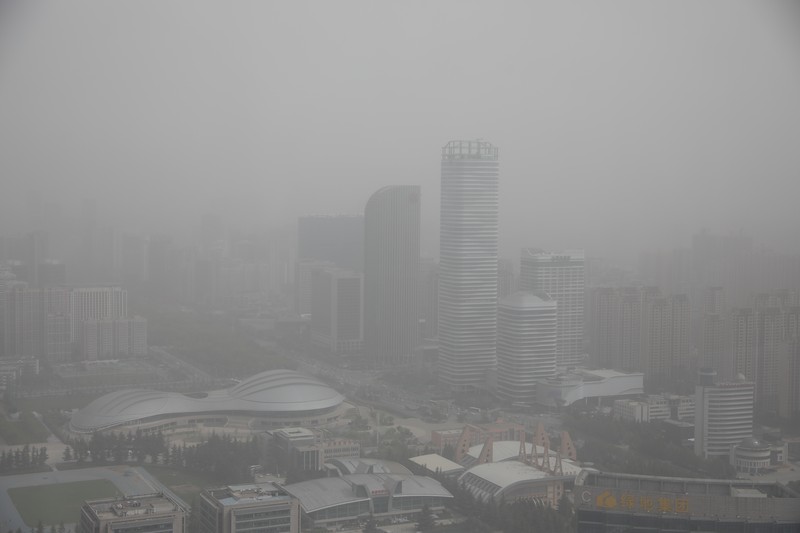 Distrik pesisir timur terlihat dalam debu yang mengambang di Kota Lianyungang, provinsi Jiangsu, China Timur pada 11 April 2023. (CFOTO/Future Publishing via Getty Images)