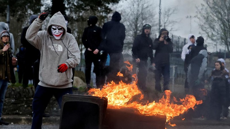 Pembangkang republik melemparkan bom bensin ke mobil polisi setelah unjuk rasa anti-Perjanjian Jumat Agung pada peringatan 25 tahun perjanjian damai, di Londonderry, Irlandia Utara, 10 April 2023. (REUTERS/Clodagh Kilcoyne)