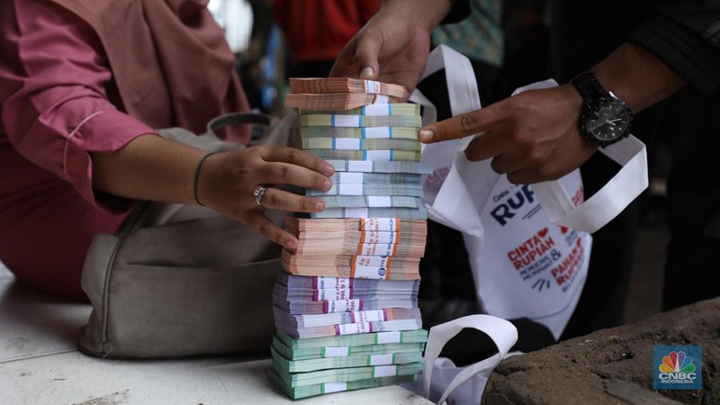 Warga menukarkan pecahan uang baru di mobil kas keliling Bank Indonesia (BI) di Pasar Palmerah, Jakarta, Selasa (11/4/2023). (CNBC Indonesia/Tri Susilo)