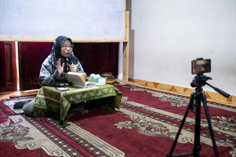 Indonesian student Nuni Nuraini Ahyani, 25, leaves the house to give a lesson on Hadith for new students during the holy month of Ramadan, after her day studying Usul al-Din with a specialization in Hadith at Al-Azhar University in old Islamic Cairo, Egypt April 4, 2023. REUTERS/Fatma Fahmy