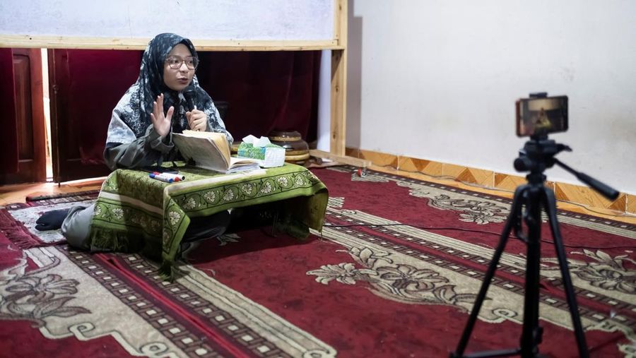Indonesian student Nuni Nuraini Ahyani, 25, leaves the house to give a lesson on Hadith for new students during the holy month of Ramadan, after her day studying Usul al-Din with a specialization in Hadith at Al-Azhar University in old Islamic Cairo, Egypt April 4, 2023. REUTERS/Fatma Fahmy