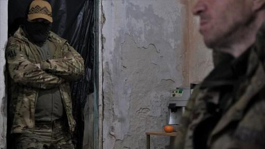 A Ukrainian serviceman (L) looks on while a member of the Russian paramilitary group Wagner and former criminal prisoner (R) sits in the interrogation room after being captured by Ukrainian soldiers near Bakhmut, Donetsk region, on March 12, 2023, amid the Russian invasion of Ukraine. (Photo by Sergey SHESTAK / AFP)