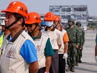 Warga sipil dan tentara berdiri selama latihan tahunan pertahanan sipil Minan, yang tahun ini berfokus pada tanggapan dari berbagai lembaga dan kelompok sukarelawan jika diserang oleh China, di Taichung, Taiwan, 13 April 2023. (REUTERS/Ann Wang)