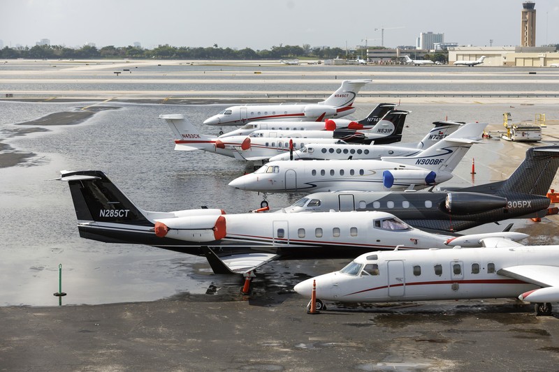 Private jets parked next to traffic control towers as the runway remains flooded from heavy rain at Fort Lauderdale-Hollywood International Airport on Thursday, April 13, 2023. (David Santiago/Miami Herald via AP)