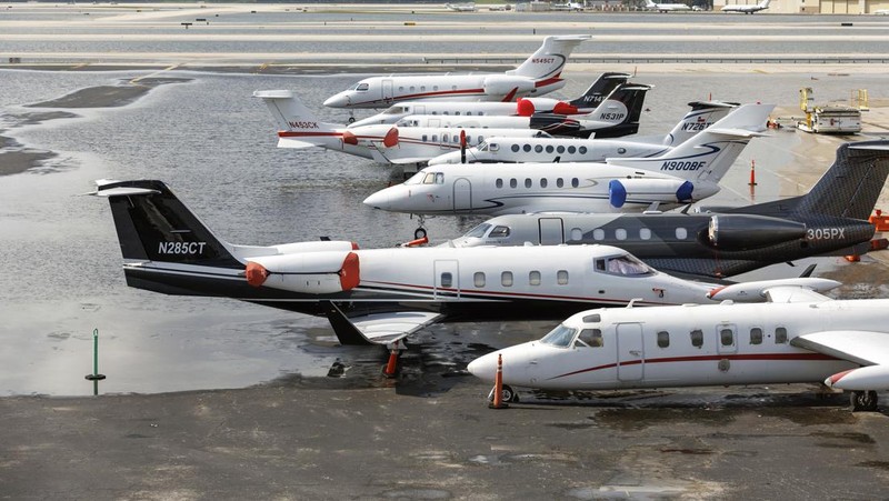 Private jets parked next to traffic control towers as the runway remains flooded from heavy rain at Fort Lauderdale-Hollywood International Airport on Thursday, April 13, 2023. (David Santiago/Miami Herald via AP)