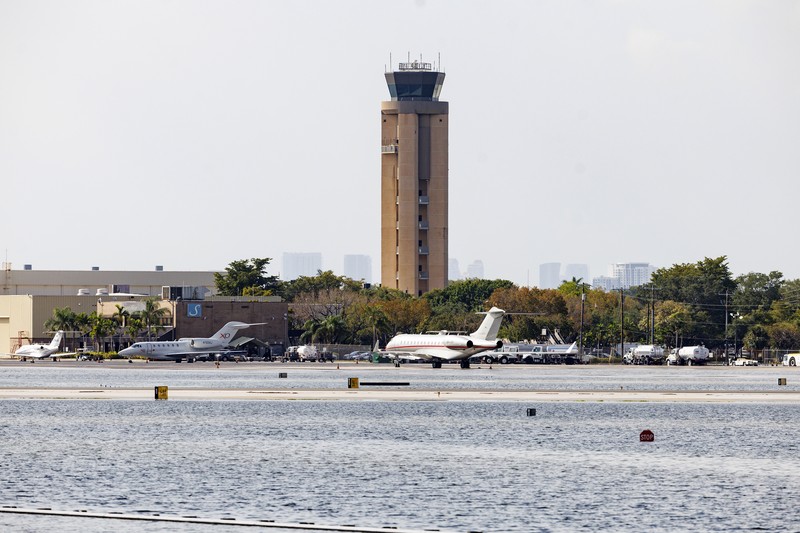 Private jets parked next to traffic control towers as the runway remains flooded from heavy rain at Fort Lauderdale-Hollywood International Airport on Thursday, April 13, 2023. (David Santiago/Miami Herald via AP)