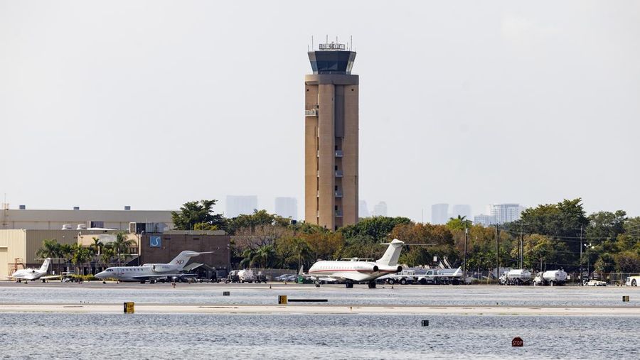 Private jets parked next to traffic control towers as the runway remains flooded from heavy rain at Fort Lauderdale-Hollywood International Airport on Thursday, April 13, 2023. (David Santiago/Miami Herald via AP)