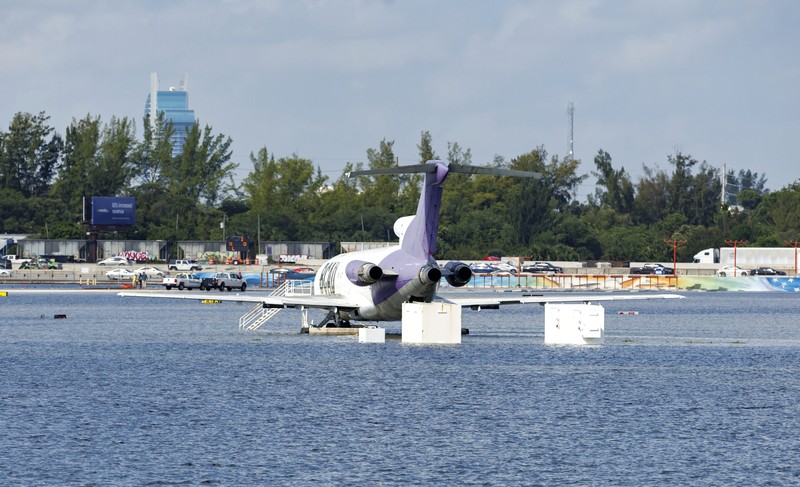 Private jets parked next to traffic control towers as the runway remains flooded from heavy rain at Fort Lauderdale-Hollywood International Airport on Thursday, April 13, 2023. (David Santiago/Miami Herald via AP)