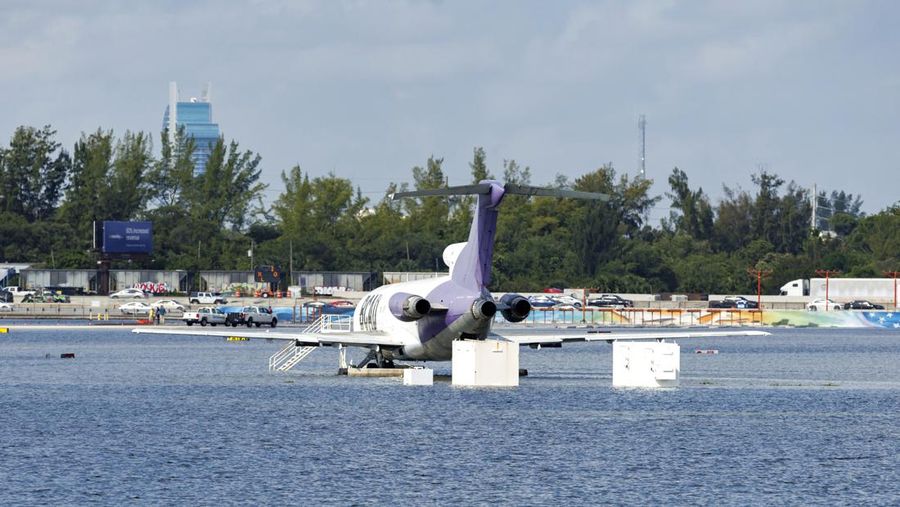 Private jets parked next to traffic control towers as the runway remains flooded from heavy rain at Fort Lauderdale-Hollywood International Airport on Thursday, April 13, 2023. (David Santiago/Miami Herald via AP)