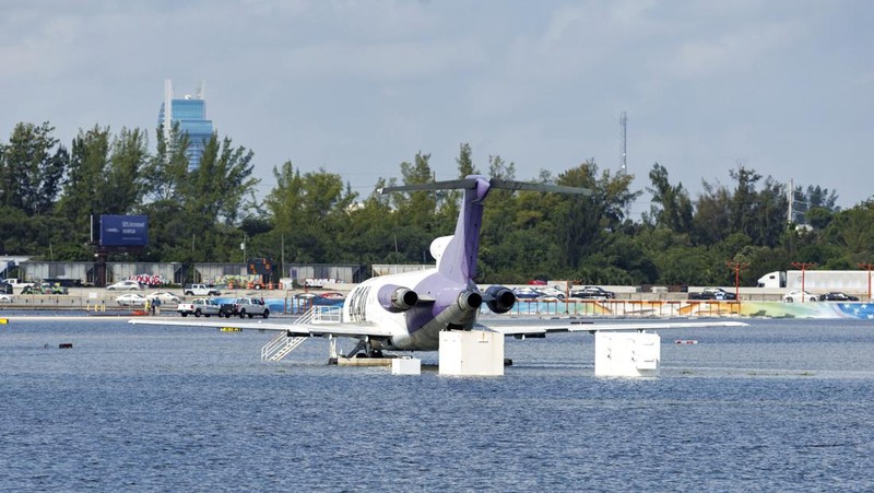 Private jets parked next to traffic control towers as the runway remains flooded from heavy rain at Fort Lauderdale-Hollywood International Airport on Thursday, April 13, 2023. (David Santiago/Miami Herald via AP)