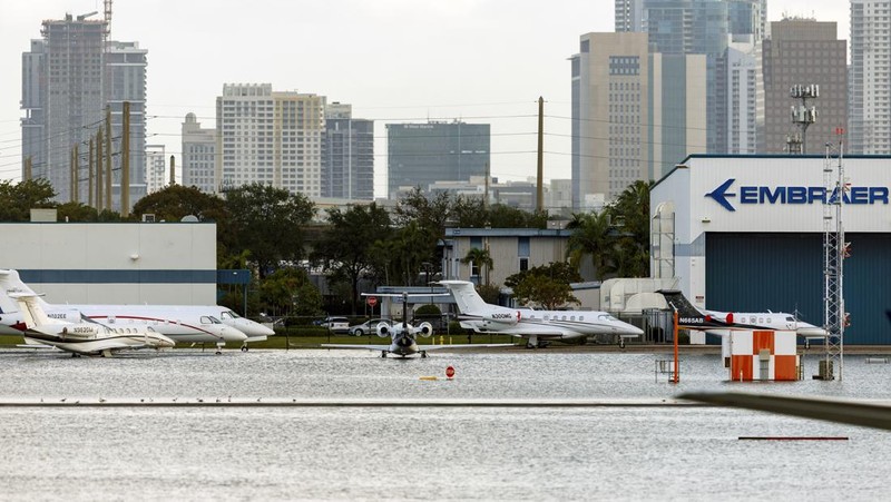 Private jets parked next to traffic control towers as the runway remains flooded from heavy rain at Fort Lauderdale-Hollywood International Airport on Thursday, April 13, 2023. (David Santiago/Miami Herald via AP)
