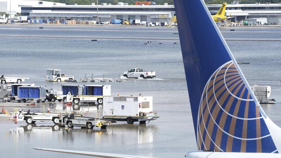 A truck drives on the flooded runway at Fort Lauderdale- Hollywood International Airport, Thursday, April 13, 2023, in Fort Lauderdale, Fla. Fort Lauderdale issued a state of emergency as flood conditions continued through many areas. Over 25 inches of rain fell in South Florida since Monday causing widespread flooding.(AP Photo/Marta Lavandier)