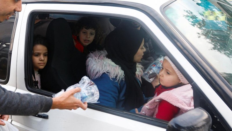 Seorang pria Kristen Palestina Ehab Ayyad menawarkan kurma dan air kepada umat Islam yang terjebak kemacetan atau terlambat pulang untuk berbuka puasa selama Ramadhan, di Kota Gaza 12 April 2023. (REUTERS/Ibraheem Abu Mustafa)