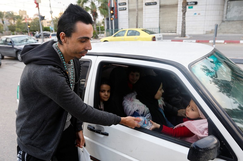Seorang pria Kristen Palestina Ehab Ayyad menawarkan kurma dan air kepada umat Islam yang terjebak kemacetan atau terlambat pulang untuk berbuka puasa selama Ramadhan, di Kota Gaza 12 April 2023. Seorang pria Kristen Palestina Ehab Ayyad menawarkan kurma dan air kepada umat Islam yang terjebak kemacetan atau terlambat pulang untuk berbuka puasa selama Ramadhan, di Kota Gaza 12 April 2023. (REUTERS/Ibraheem Abu Mustafa)