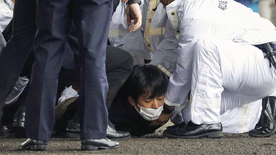 Seorang pria, diyakini sebagai tersangka yang melemparkan benda mirip pipa di dekat Perdana Menteri Jepang Fumio Kishida selama pidatonya di luar ruangan. (via REUTERS/KYODO)