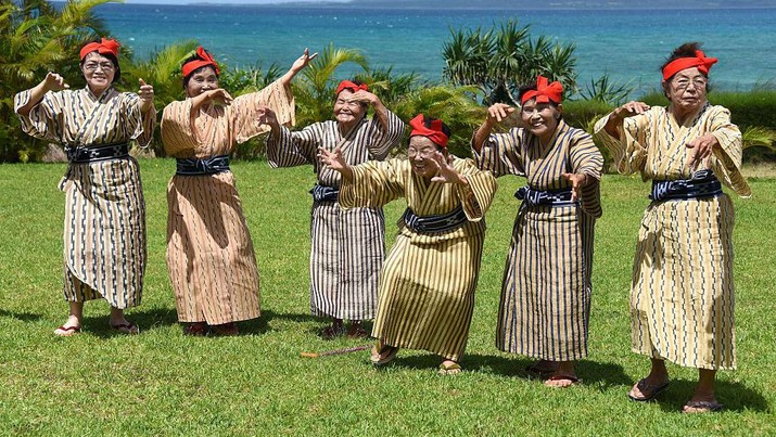 TO GO WITH AFP STORY BY ALASTAIR HIMMER
In this picture taken on June 22, 2015, an elderly women troupe of singers and dancers from Kohama Island in Okinawa wearing traditional local costumes perform at a herb garden on Kohama Island, Okinawa Prefecture. They joke about knocking on heaven's door, but a Japanese 'girl band' named KBG84, with an average age of 84 have struck a blow for grannies everywhere by becoming pop idols. AFP PHOTO / Toru YAMANAKA        (Photo credit should read TORU YAMANAKA/AFP via Getty Images)