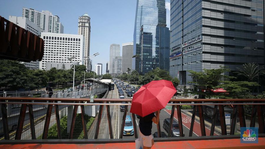 Warga menggunakan payung untuk menghindari paparan sinar matahari di kawasan Jakarta, Senin (17/4/2023). (վ/Tri Susilo)