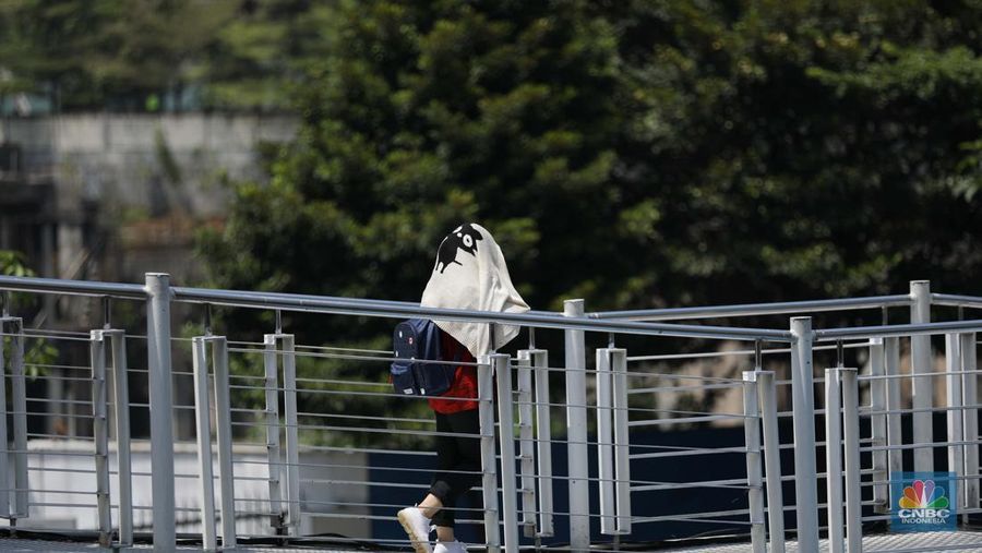 Seorang wanita menggunakan kipas tangan saat suhu mencapai rekor 45,4 derajat Celcius (113,7 Fahrenheit) di Bangkok, Thailand, 22 April 2023. (REUTERS/Chalinee Thirasupa)