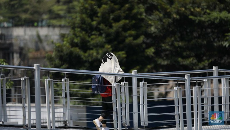 Seorang wanita menggunakan kipas tangan saat suhu mencapai rekor 45,4 derajat Celcius (113,7 Fahrenheit) di Bangkok, Thailand, 22 April 2023. (REUTERS/Chalinee Thirasupa)