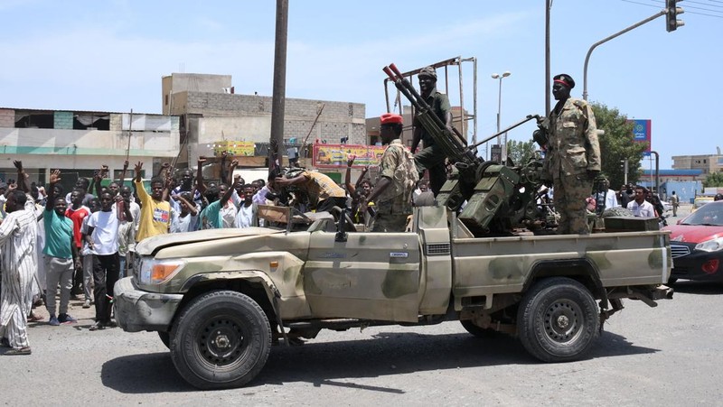 Warga Sudan menyapa tentara, yang setia kepada panglima militer Abdel Fattah al-Burhan, di kota Laut Merah Port Sudan pada 16 April 2023. - Pejuang yang berjuang di Sudan mengatakan mereka telah menyetujui jeda kemanusiaan selama berjam-jam, termasuk untuk mengevakuasi yang terluka , pada hari kedua pertempuran kota yang berkecamuk yang menewaskan lebih dari 50 warga sipil termasuk tiga staf PBB dan memicu protes internasional. (-/AFP via Getty Images)