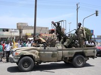 Warga Sudan menyapa tentara, yang setia kepada panglima militer Abdel Fattah al-Burhan, di kota Laut Merah Port Sudan pada 16 April 2023. - Pejuang yang berjuang di Sudan mengatakan mereka telah menyetujui jeda kemanusiaan selama berjam-jam, termasuk