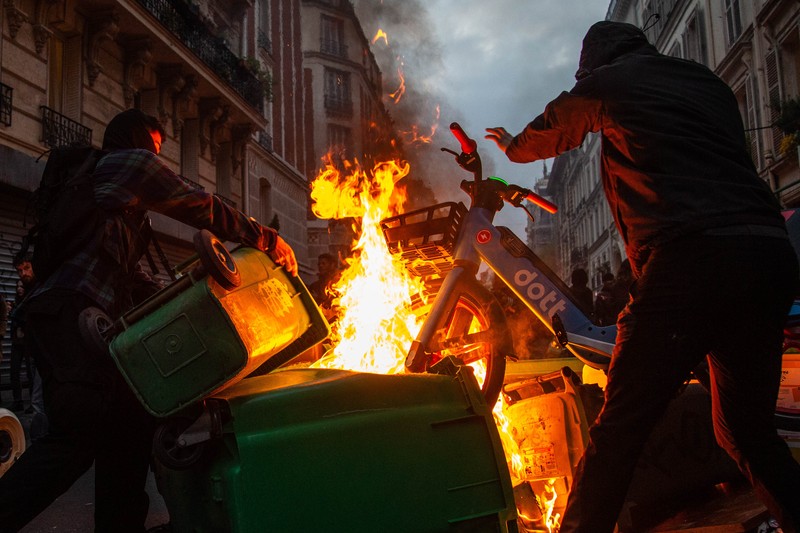 Para pengunjuk rasa berkumpul ketika seorang demonstran memegang topeng yang menggambarkan Presiden Prancis Emmanuel Macron dan berpakaian seperti seorang raja, selama demonstrasi menyusul pidato khusus kepada negara oleh Macron, setelah dia menandatangani undang-undang reformasi pensiun yang menaikkan usia pensiun, di Paris, Prancis, 17 April 2023. Para pengunjuk rasa berkumpul ketika seorang demonstran memegang topeng yang menggambarkan Presiden Prancis Emmanuel Macron dan berpakaian seperti seorang raja, selama demonstrasi menyusul pidato khusus kepada negara oleh Macron, setelah dia menandatangani undang-undang reformasi pensiun yang menaikkan usia pensiun, di Paris, Prancis, 17 April 2023. (REUTERS/Stephanie Lecocq)