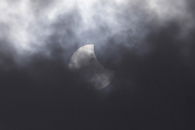 Warga menggunakan kacamata pelindung untuk menyaksikan gerhana matahari di Jakarta, Indonesia, Kamis, 20 April 2023. (AP/Tatan Syuflana)