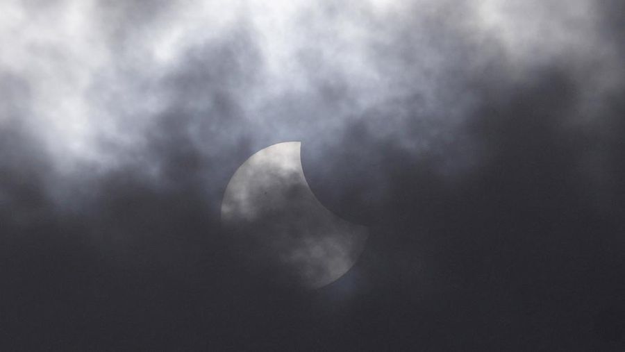 Warga menggunakan kacamata pelindung untuk menyaksikan gerhana matahari di Jakarta, Indonesia, Kamis, 20 April 2023. (AP/Tatan Syuflana)
