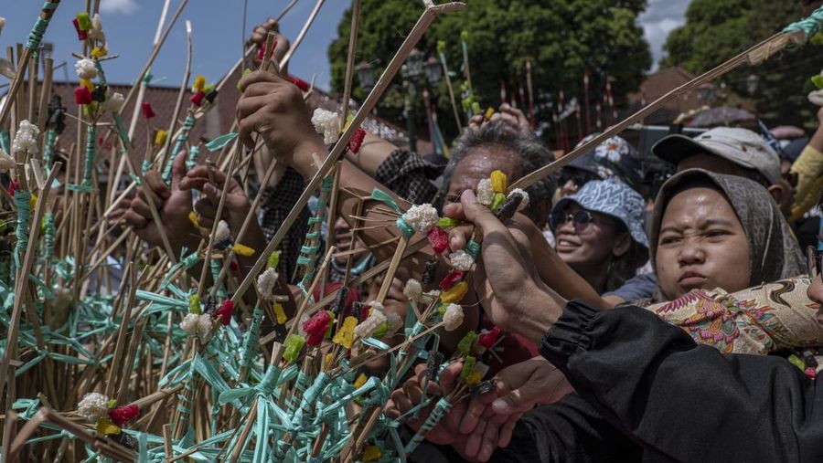 Masyarakat Jawa berebut 'Gunungan', sebuah kurban berbentuk gunung, saat upacara Grebeg Syawalan sebagai bagian dari perayaan Idul Fitri di Masjid Agung Kauman pada 22 April 2023 di Yogyakarta, Indonesia. Grebeg Syawal merupakan tradisi yang mengikuti bulan suci Ramadan untuk menyambut Idul Fitri. Tradisi tersebut berupa sesaji sayuran, paprika, telur, dan barang-barang lainnya yang disebut 'Gunungan Wadon' dan 'Gunungan Lanang' yang dibawa ke Masjid Raya sebagai bagian dari simbol sedekah Sri Sultan Hamengkubuwono X kepada rakyatnya. Menerima sebagian Gunungan dipercaya membawa keberuntungan dan berkah untuk setahun ke depan. (Ulet Ifansasti/Getty Images)