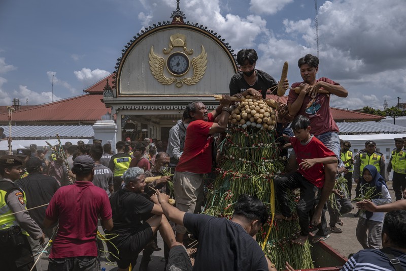 Masyarakat Jawa berebut 'Gunungan', sebuah kurban berbentuk gunung, saat upacara Grebeg Syawalan sebagai bagian dari perayaan Idul Fitri di Masjid Agung Kauman pada 22 April 2023 di Yogyakarta, Indonesia. Masyarakat Jawa berebut 'Gunungan', sebuah kurban berbentuk gunung, saat upacara Grebeg Syawalan sebagai bagian dari perayaan Idul Fitri di Masjid Agung Kauman pada 22 April 2023 di Yogyakarta, Indonesia. Grebeg Syawal merupakan tradisi yang mengikuti bulan suci Ramadan untuk menyambut Idul Fitri. Tradisi tersebut berupa sesaji sayuran, paprika, telur, dan barang-barang lainnya yang disebut 'Gunungan Wadon' dan 'Gunungan Lanang' yang dibawa ke Masjid Raya sebagai bagian dari simbol sedekah Sri Sultan Hamengkubuwono X kepada rakyatnya. Menerima sebagian Gunungan dipercaya membawa keberuntungan dan berkah untuk setahun ke depan. (Ulet Ifansasti/Getty Images)