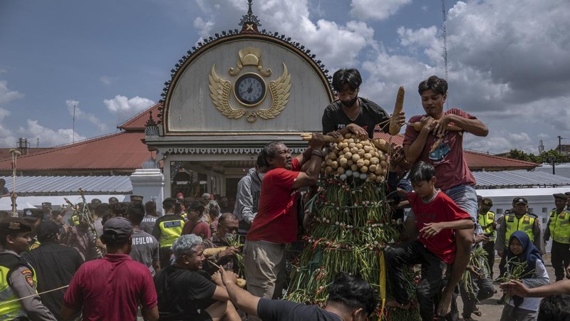 Masyarakat Jawa berebut 'Gunungan', sebuah kurban berbentuk gunung, saat upacara Grebeg Syawalan sebagai bagian dari perayaan Idul Fitri di Masjid Agung Kauman pada 22 April 2023 di Yogyakarta, Indonesia. Grebeg Syawal merupakan tradisi yang mengikuti bulan suci Ramadan untuk menyambut Idul Fitri. Tradisi tersebut berupa sesaji sayuran, paprika, telur, dan barang-barang lainnya yang disebut 'Gunungan Wadon' dan 'Gunungan Lanang' yang dibawa ke Masjid Raya sebagai bagian dari simbol sedekah Sri Sultan Hamengkubuwono X kepada rakyatnya. Menerima sebagian Gunungan dipercaya membawa keberuntungan dan berkah untuk setahun ke depan. (Ulet Ifansasti/Getty Images)