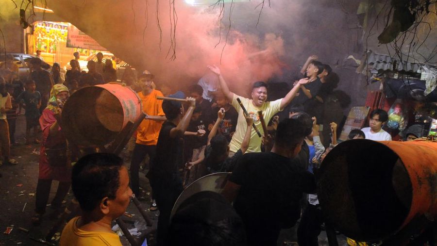 MANGGARAI, JAKARTA - APRIL 21 : People light flares and beat drums as they celebrate Idul Fitri, the holiday marking the end of the fasting month of Ramadan, on Jalan Tambak in Jakarta, Indonesia, on April 21, 2023. The end of Ramandan residents choose to do celebrating with takbir, beating drums and setting off firecrackers for celebration because it's been a full month for Muslims fasting. (Photo by Dasril Roszandi/Anadolu Agency via Getty Images)