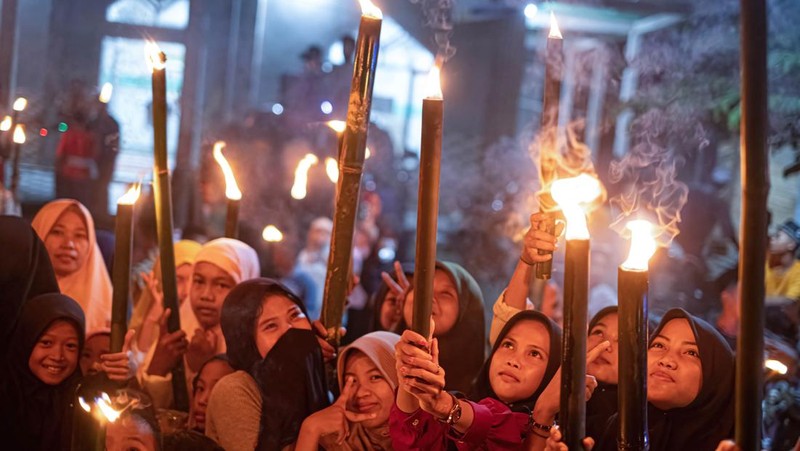 YOGYAKARTA, INDONESIA - APRIL 21: Indonesian Muslims play with fire during a parade as Muslims celebrate Eid Al-Fitr to mark the end of the holy month of Ramadan on April 21, 2023 in Yogyakarta, Indonesia. Muslims around the world celebrate Eid al-Fitr with their families with feasts to mark the end of Ramadan, the holy month of fasting. (Photo by Ulet Ifansasti/Getty Images)