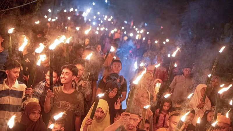 YOGYAKARTA, INDONESIA - APRIL 21: Indonesian Muslims play with fire during a parade as Muslims celebrate Eid Al-Fitr to mark the end of the holy month of Ramadan on April 21, 2023 in Yogyakarta, Indonesia. Muslims around the world celebrate Eid al-Fitr with their families with feasts to mark the end of Ramadan, the holy month of fasting. (Photo by Ulet Ifansasti/Getty Images)
