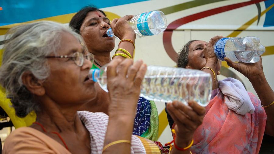 Women are drinking water from water bottles on a hot summer day in Kolkata, India on 13 April 2023. Met Office predicts heatwave in Kolkata and several West Bengal districts. According to the IMD special bulletin, an orange alert has been announced for the districts of South Bengal during April 12-16. (Photo by Sudipta Das/NurPhoto via Getty Images)