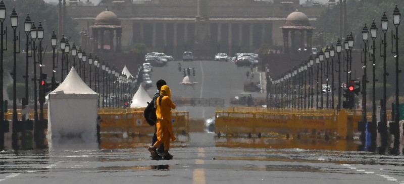 People walk through a dust storm on a hot summer day in Prayagraj on April 18, 2023. (Photo by Sanjay KANOJIA / AFP) (Photo by SANJAY KANOJIA/AFP via Getty Images)