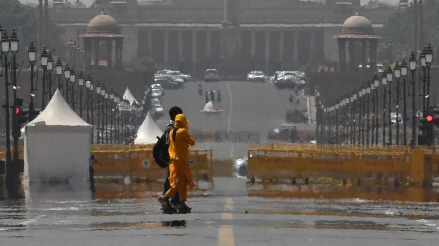 People walk through a dust storm on a hot summer day in Prayagraj on April 18, 2023. (Photo by Sanjay KANOJIA / AFP) (Photo by SANJAY KANOJIA/AFP via Getty Images)