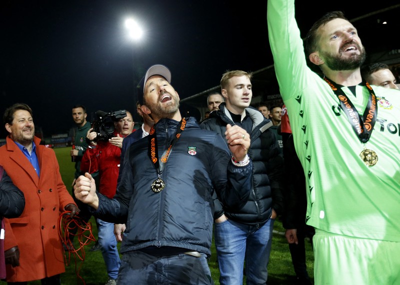 SOCCER-ENGLAND-WXH-BWD/REPORT Soccer Football - National League - Wrexham v Boreham Wood - Racecourse Ground, Wrexham, Britain - April 22, 2023 Wrexham co-owners Rob McElhenney and Ryan Reynolds celebrate with the trophy on the pitch after Wrexham win the National League and promotion to League Two Action Images via Reuters/Ed Sykes EDITORIAL USE ONLY. No use with unauthorized audio, video, data, fixture lists, club/league logos or 'live' services. Online in-match use limited to 75 images, no video emulation. No use in betting, games or single club /league/player publications. Please contact your account representative for further details. TPX IMAGES OF THE DAY