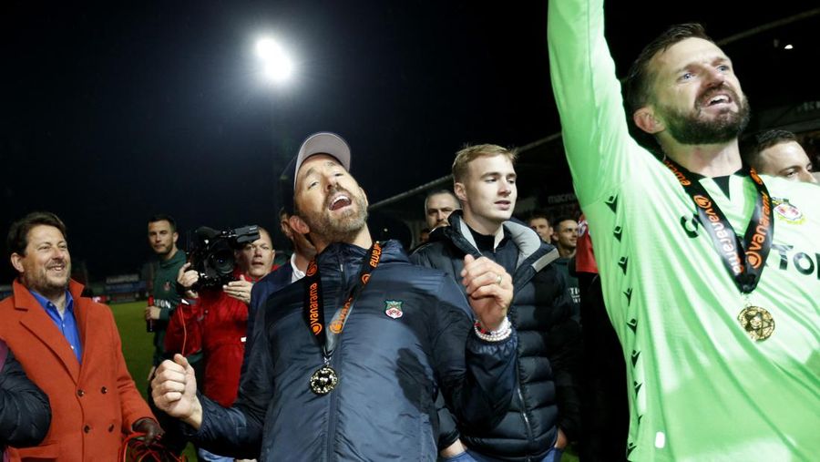Soccer Football - National League - Wrexham v Boreham Wood - Racecourse Ground, Wrexham, Britain - April 22, 2023 Wrexham co-owners Rob McElhenney and Ryan Reynolds celebrate with the trophy on the pitch after Wrexham win the National League and promotion to League Two Action Images via Reuters/Ed Sykes EDITORIAL USE ONLY. No use with unauthorized audio, video, data, fixture lists, club/league logos or 'live' services. Online in-match use limited to 75 images, no video emulation. No use in betting, games or single club /league/player publications.  Please contact your account representative for further details.     TPX IMAGES OF THE DAY