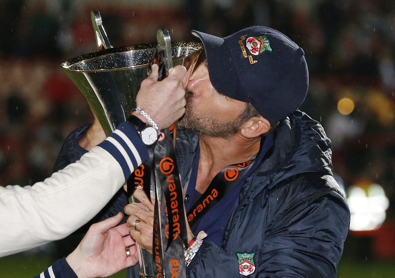 Soccer Football - National League - Wrexham v Boreham Wood - Racecourse Ground, Wrexham, Britain - April 22, 2023 Wrexham co-owners Rob McElhenney and Ryan Reynolds celebrate with the trophy on the pitch after Wrexham win the National League and promotion to League Two Action Images via Reuters/Ed Sykes EDITORIAL USE ONLY. No use with unauthorized audio, video, data, fixture lists, club/league logos or 'live' services. Online in-match use limited to 75 images, no video emulation. No use in betting, games or single club /league/player publications.  Please contact your account representative for further details.     TPX IMAGES OF THE DAY
