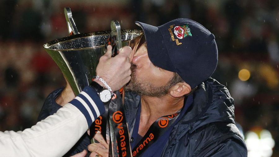 Soccer Football - National League - Wrexham v Boreham Wood - Racecourse Ground, Wrexham, Britain - April 22, 2023 Wrexham co-owners Rob McElhenney and Ryan Reynolds celebrate with the trophy on the pitch after Wrexham win the National League and promotion to League Two Action Images via Reuters/Ed Sykes EDITORIAL USE ONLY. No use with unauthorized audio, video, data, fixture lists, club/league logos or 'live' services. Online in-match use limited to 75 images, no video emulation. No use in betting, games or single club /league/player publications.  Please contact your account representative for further details.     TPX IMAGES OF THE DAY