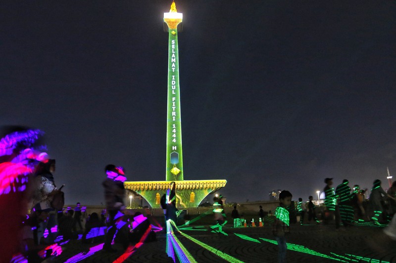 Pengunjung menyaksikan tayangan video mapping di kawasan Monas Jakarta Indonesia pada 23 April 2023. Pengunjung menyaksikan tayangan video mapping di kawasan Monas Jakarta Indonesia pada 23 April 2023. Bertepatan dengan libur Idul Fitri, Pemprov DKI Jakarta menggelar Pekan Kegiatan Monas 2023 yang ditandai dengan tayangan video mapping. (Eko Siswono Toyudho/Anadolu Agency via Getty Images)