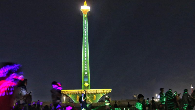 Pengunjung menyaksikan tayangan video mapping di kawasan Monas Jakarta Indonesia pada 23 April 2023. Bertepatan dengan libur Idul Fitri, Pemprov DKI Jakarta menggelar Pekan Kegiatan Monas 2023 yang ditandai dengan tayangan video mapping. (Eko Siswono Toyudho/Anadolu Agency via Getty Images)