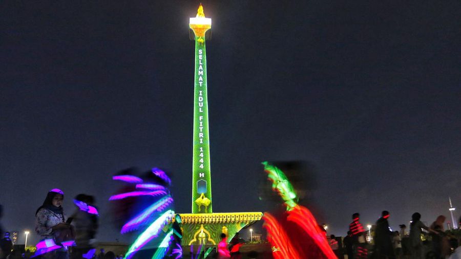 Pengunjung menyaksikan tayangan video mapping di kawasan Monas Jakarta Indonesia pada 23 April 2023. Bertepatan dengan libur Idul Fitri, Pemprov DKI Jakarta menggelar Pekan Kegiatan Monas 2023 yang ditandai dengan tayangan video mapping. (Eko Siswono Toyudho/Anadolu Agency via Getty Images)