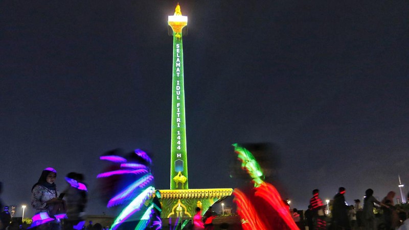 Pengunjung menyaksikan tayangan video mapping di kawasan Monas Jakarta Indonesia pada 23 April 2023. Bertepatan dengan libur Idul Fitri, Pemprov DKI Jakarta menggelar Pekan Kegiatan Monas 2023 yang ditandai dengan tayangan video mapping. (Eko Siswono Toyudho/Anadolu Agency via Getty Images)