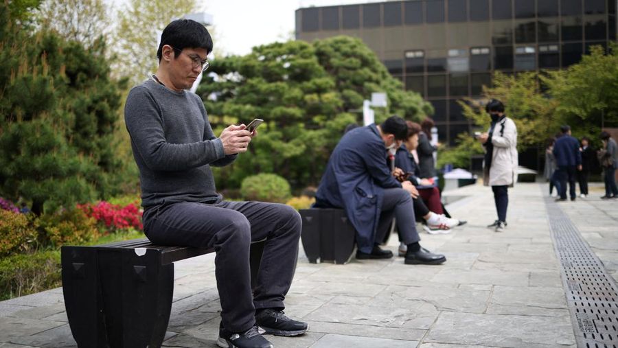 Kim Youngsuck, an office worker, looks at his mobile phone to check the local online banking app Toss at Seoul Museum of Art during a lunch break in Seoul, South Korea, April 13, 2023.   REUTERS/Kim Hong-Ji