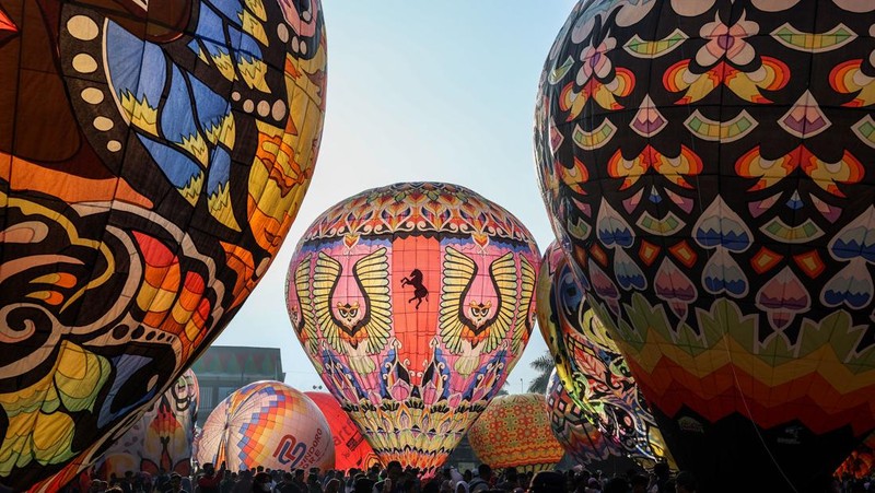 WONOSOBO, INDONESIA - APRIL 23: Hot air balloons fly over the sky during a balloon festival on the Eid al-Fitr holiday at Ronggolawe Stadion on April 23, 2023, in Wonosobo, Central Java, Indonesia. Javanese people fly giant hot air balloons during Eid, which has long been a tradition of the Wonosobo regency. (Photo by Garry Lotulung/Anadolu Agency via Getty Images)