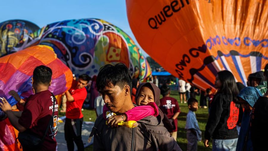 WONOSOBO, INDONESIA - APRIL 23: Hot air balloons fly over the sky during a balloon festival on the Eid al-Fitr holiday at Ronggolawe Stadion on April 23, 2023, in Wonosobo, Central Java, Indonesia. Javanese people fly giant hot air balloons during Eid, which has long been a tradition of the Wonosobo regency. (Photo by Garry Lotulung/Anadolu Agency via Getty Images)