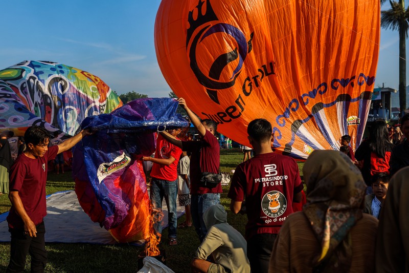 1252105442 WONOSOBO, INDONESIA - APRIL 23: Hot air balloons fly over the sky during a balloon festival on the Eid al-Fitr holiday at Ronggolawe Stadion on April 23, 2023, in Wonosobo, Central Java, Indonesia. Javanese people fly giant hot air balloons during Eid, which has long been a tradition of the Wonosobo regency. (Photo by Garry Lotulung/Anadolu Agency via Getty Images)