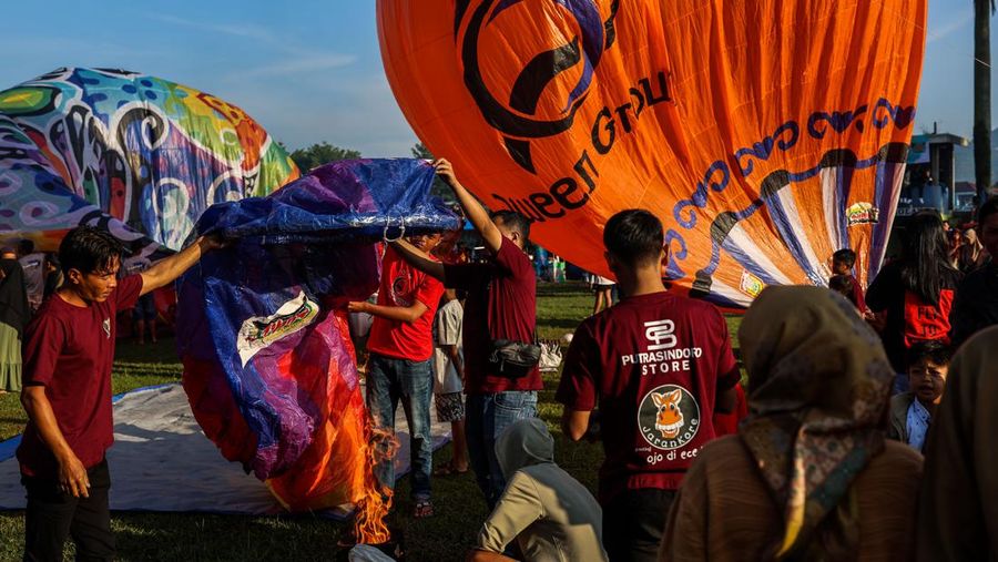WONOSOBO, INDONESIA - APRIL 23: Hot air balloons fly over the sky during a balloon festival on the Eid al-Fitr holiday at Ronggolawe Stadion on April 23, 2023, in Wonosobo, Central Java, Indonesia. Javanese people fly giant hot air balloons during Eid, which has long been a tradition of the Wonosobo regency. (Photo by Garry Lotulung/Anadolu Agency via Getty Images)